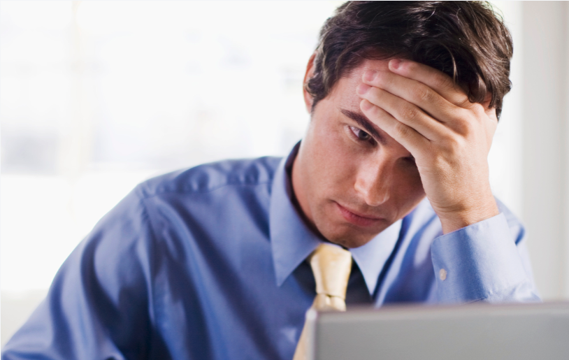 Man looking at computer feeling frustrated